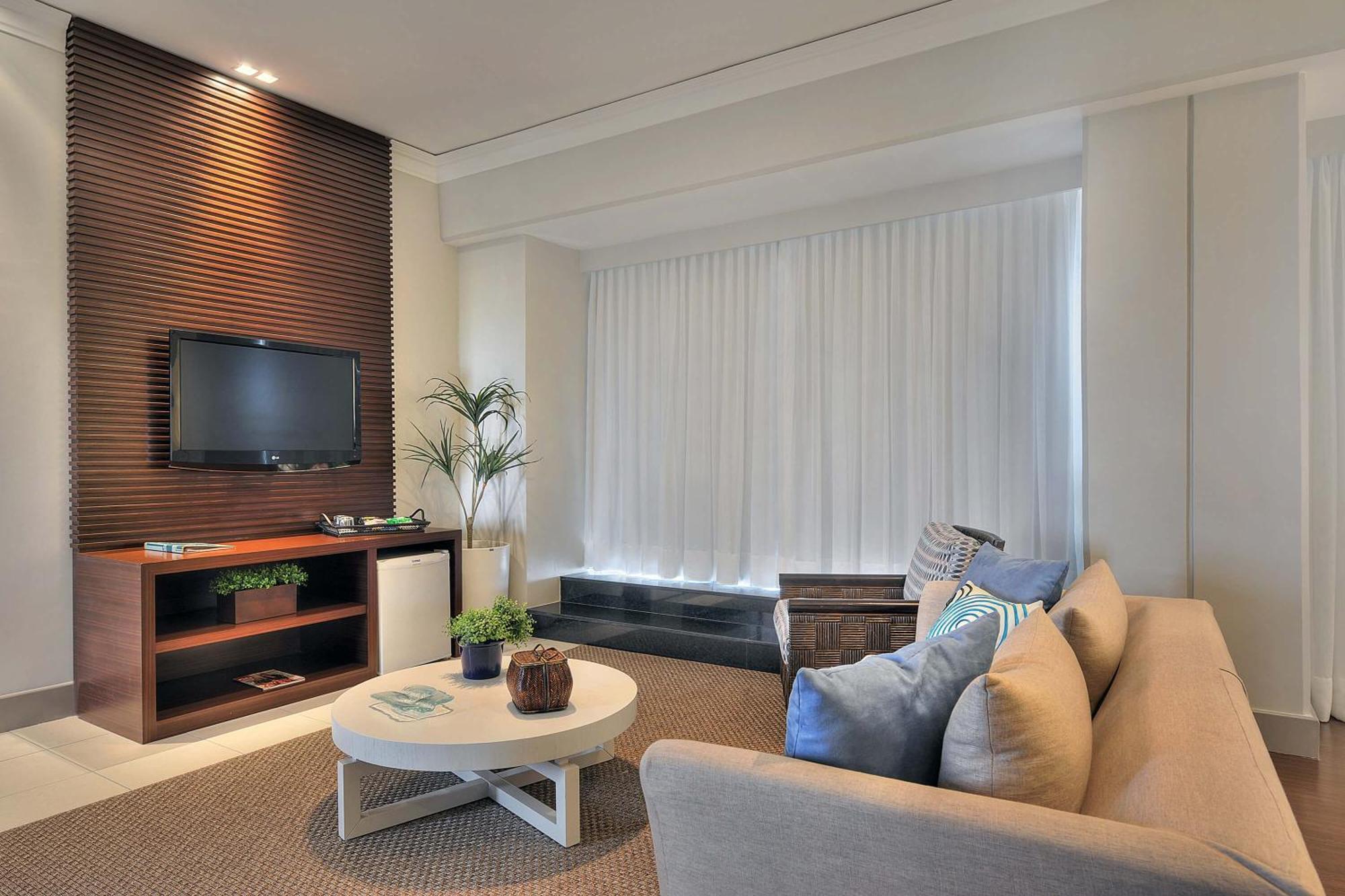 Hotel Deville Prime Salvador Bagian luar foto A living room with a television